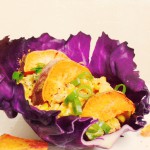 Fiesta Chipotle Corn Salad with roasted Yams, spring onions on a purple cabbage leaf. *organic,vegan and gluten free*